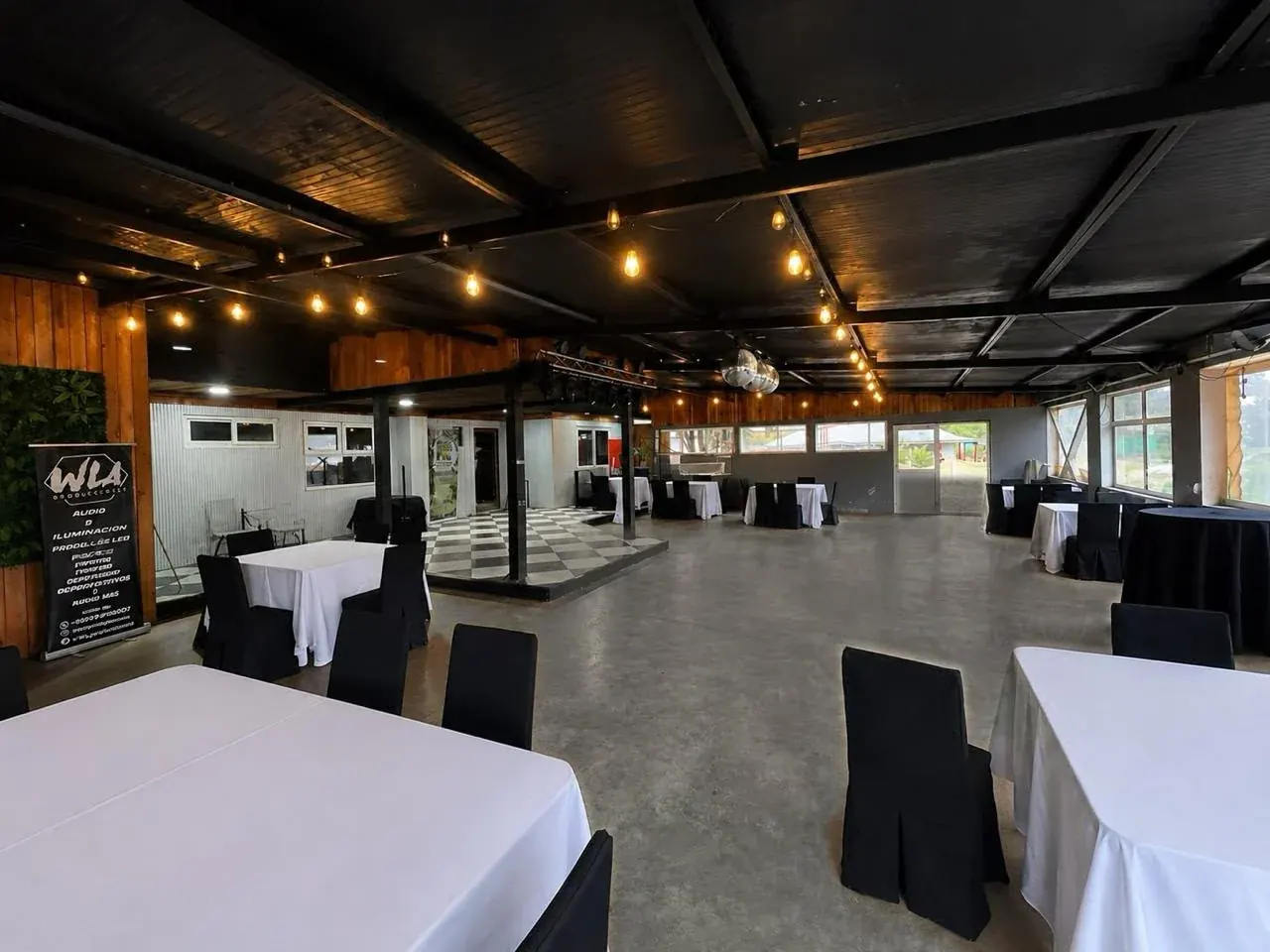 Salón interior de Espacio Nonguén con mesas, iluminación cálida y pista de baile