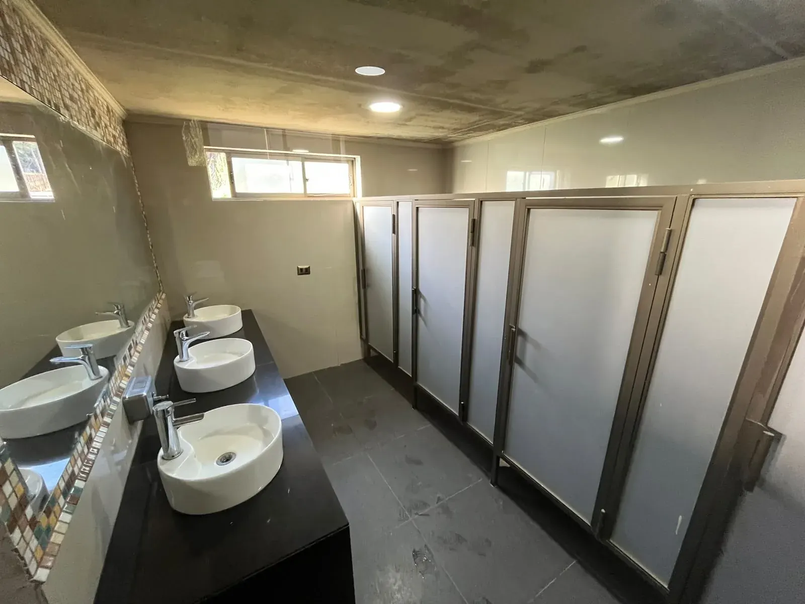 Baños de La Pastrana con cubículos y lavamanos