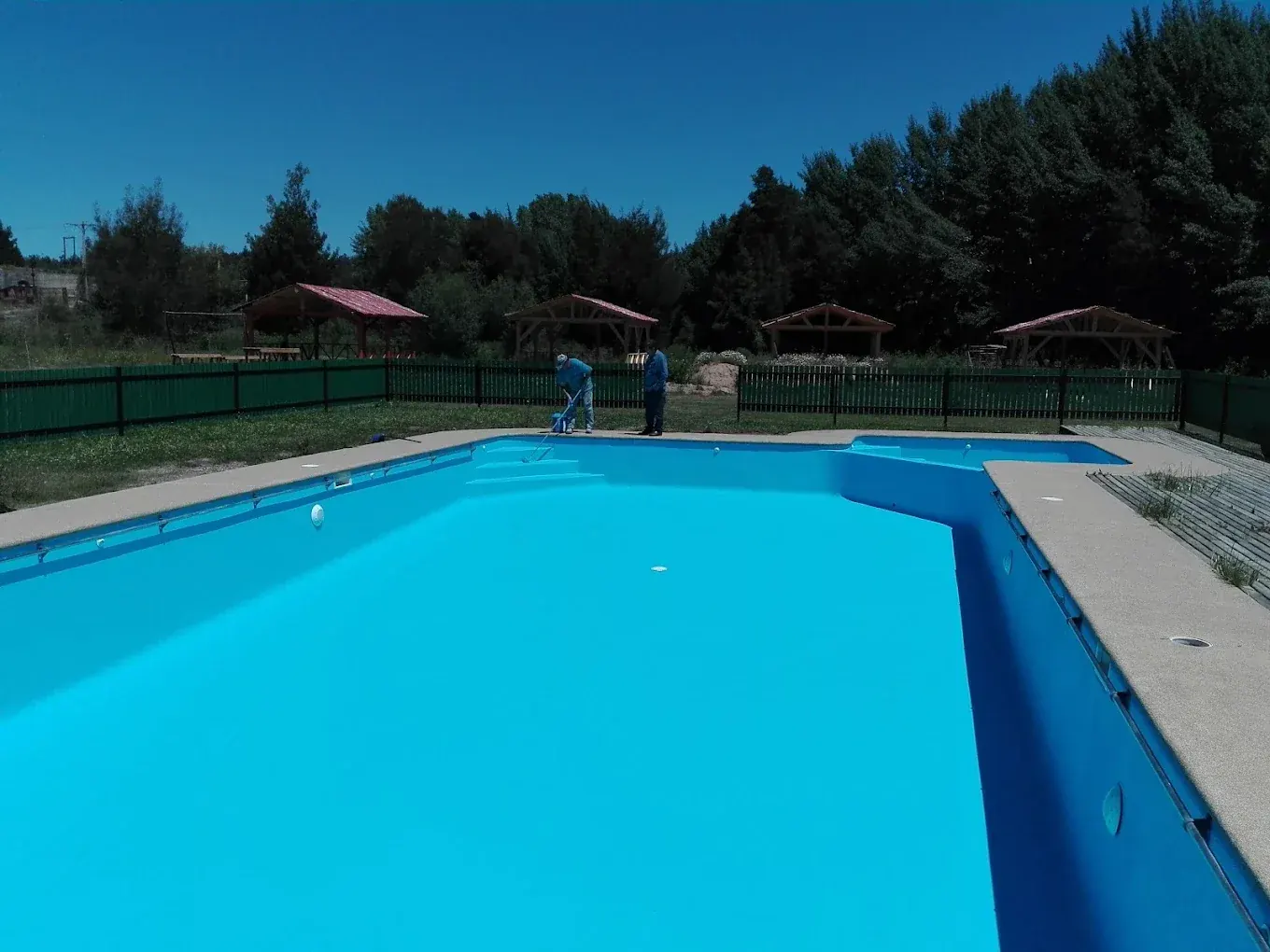Vista de la piscina de La Pastrana con quinchos al fondo